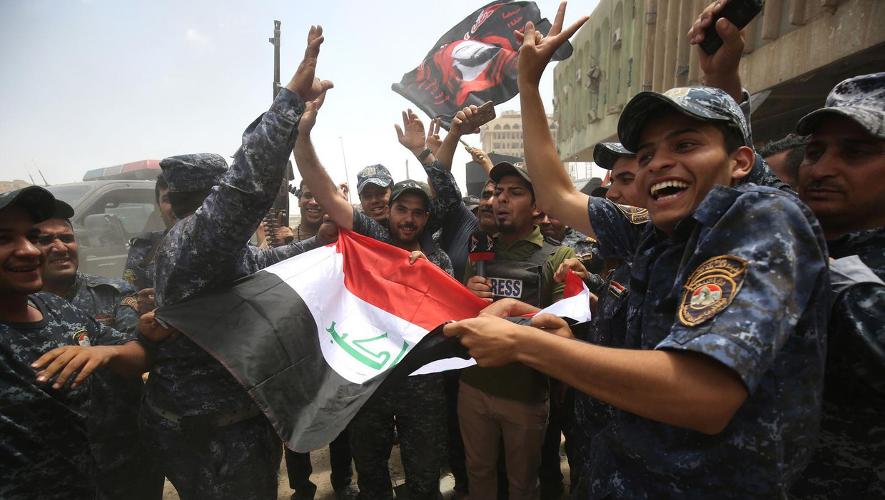 Iraakse militairen en agenten vieren de overwinning op IS in Mosul. Beeld Ahmad Al-Rubaye / AFP