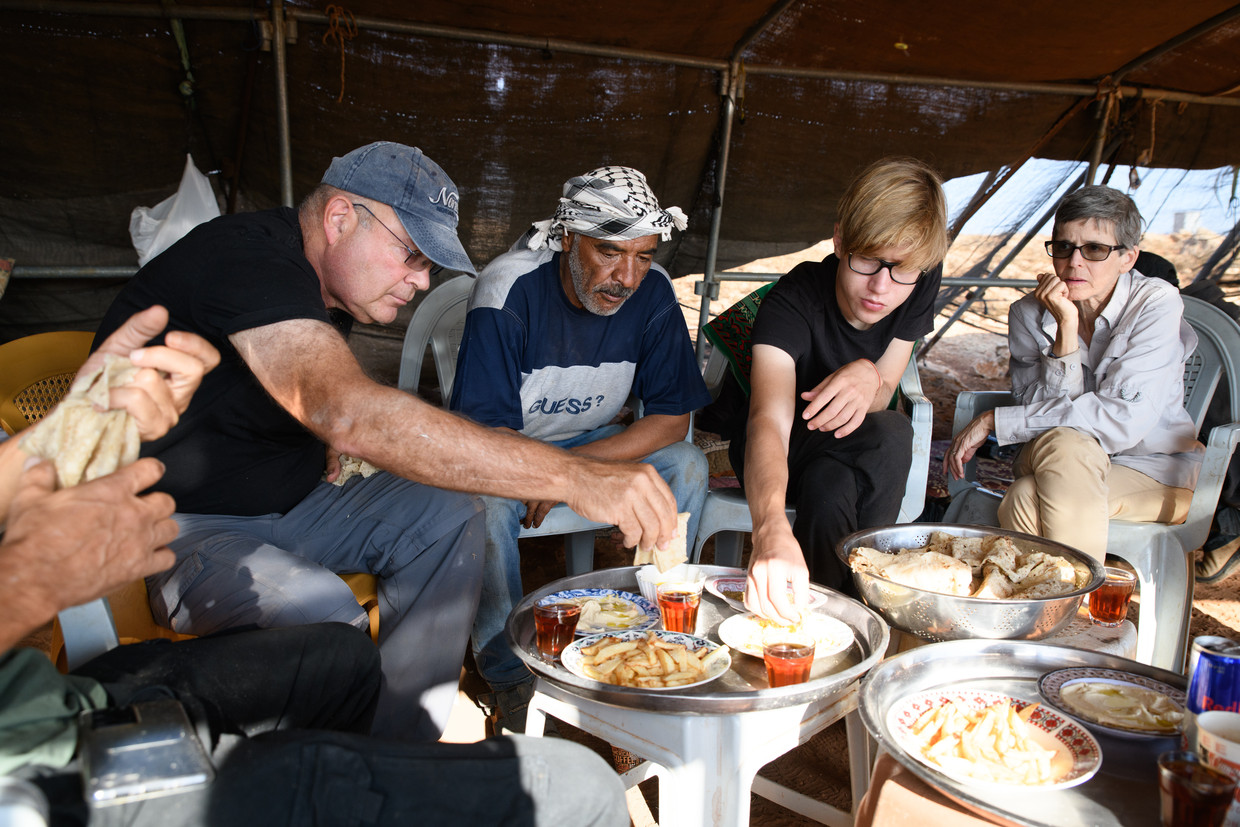 Israëlische activisten die de bewoners van Rashash hebben beschermd tegen kolonisten krijgen lunch van de bewoners. Rechts Rebekah Levin.  Beeld Matan Golan voor de Volkskrant