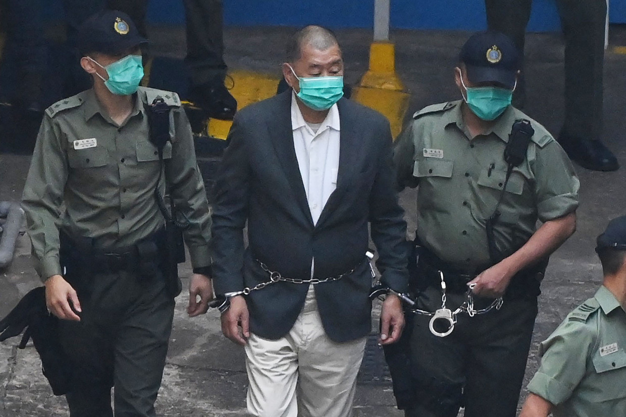 Jimmy Loy (center) is escorted by authorities on his way to court in December 2020.  Image by AFP