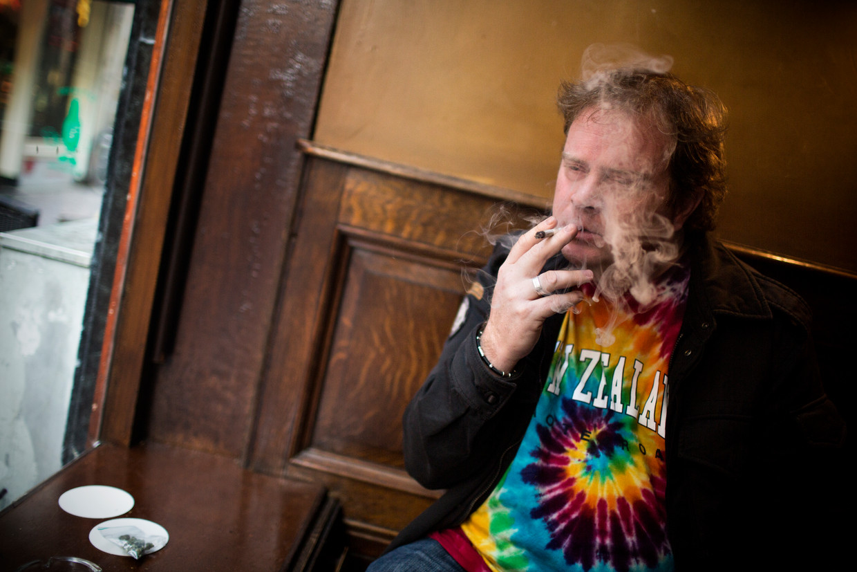 Een toerist rookt een joint in een Amsterdamse coffeeshop. Beeld Julius Schrank / Kollektiv25
