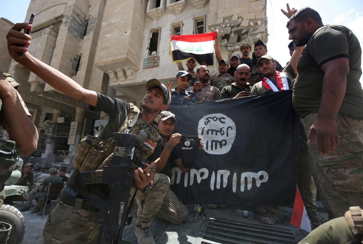 Iraakse militairen en agenten vieren de overwinning op IS in Mosul. Beeld Ahmad Al-Rubaye / AFP
